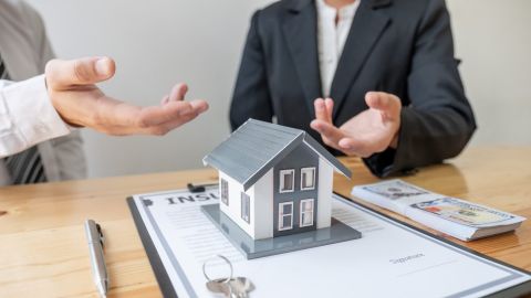Banquero hipotecario habla con un cliente sobre la compra de una vivienda y su hipoteca.