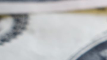 Monedas de 1 centavo de dólar sobre billetes de $100.