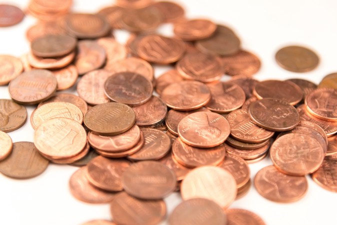 Centavos de dólar esparcidos sobre fondo blanco.