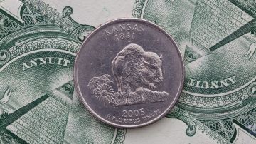 Moneda de 25 centavos de Kansas sobre billetes estadounidenses.