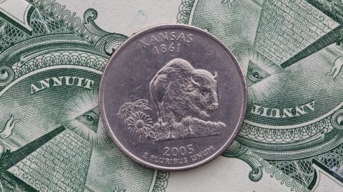 Moneda de 25 centavos de Kansas sobre billetes estadounidenses.