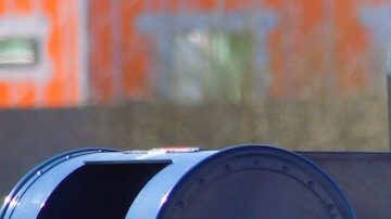 Un trabajador postal de USPS recoge el correo saliente en un buzón de entrega.