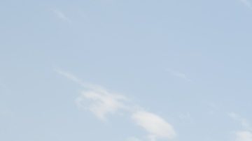 Vista trasera de una mujer caminando hacia un jet privado mientras el piloto y las azafatas estaban parados en la terminal del aeropuerto.