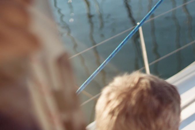El hombre mayor está trabajando durante las vacaciones en un velero.