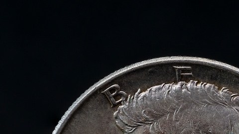 Medio dólar de plata Kennedy de 1964 sobre fondo negro reflejante.