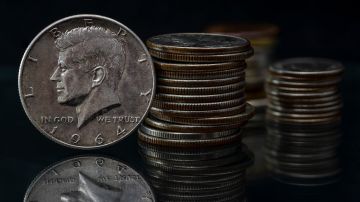 Medio dólar de plata Kennedy de 1964 sobre fondo negro reflejante.