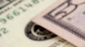 Primer plano del cheque de declaración de impuestos y moneda estadounidense.