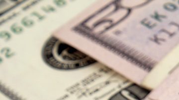 Primer plano del cheque de declaración de impuestos y moneda estadounidense.