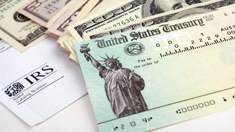 Primer plano del cheque de declaración de impuestos y moneda estadounidense.