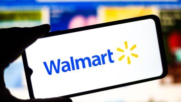 Mano muestra en un teléfono móvil el logo de Walmart.