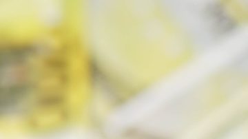 El hombre sostiene una barra de oro sobre un fondo de billetes de dinero.