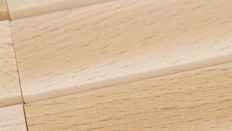 Sobre una superficie amarilla hay bloques de madera y una flecha que apunta a un bloque con la inscripción - Surcharge (Recargo).