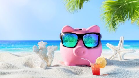 Alcancía en la playa, para representar las actividades de verano que influyen en tu declaración de impuestos.
