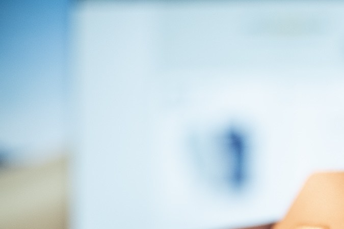 Un hombre sostiene en su mano una tarjeta Visa Signature de Amazon Prime Rewards.