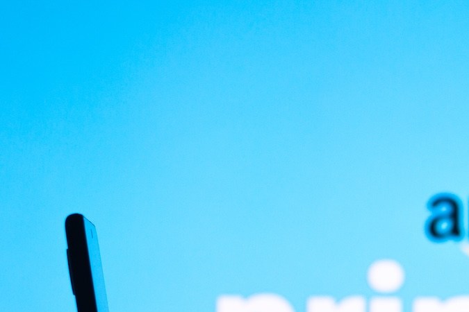 El logotipo de Amazon Prime Day se ve en el fondo de una silueta de mujer sosteniendo un teléfono móvil.