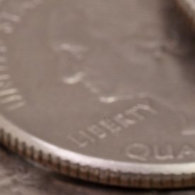 Círculo de monedas de 25 centavos de dólar de Wisconsin con dólares en el fondo.