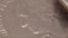 Círculo de monedas de 25 centavos de dólar de Wisconsin con dólares en el fondo.