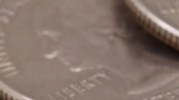 Círculo de monedas de 25 centavos de dólar de Wisconsin con dólares en el fondo.