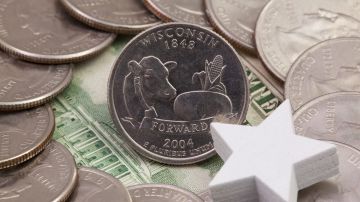 Círculo de monedas de 25 centavos de dólar de Wisconsin con dólares en el fondo.