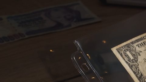 La mujer sostiene un conjunto de viejos dólares coleccionables en los bolsillos.