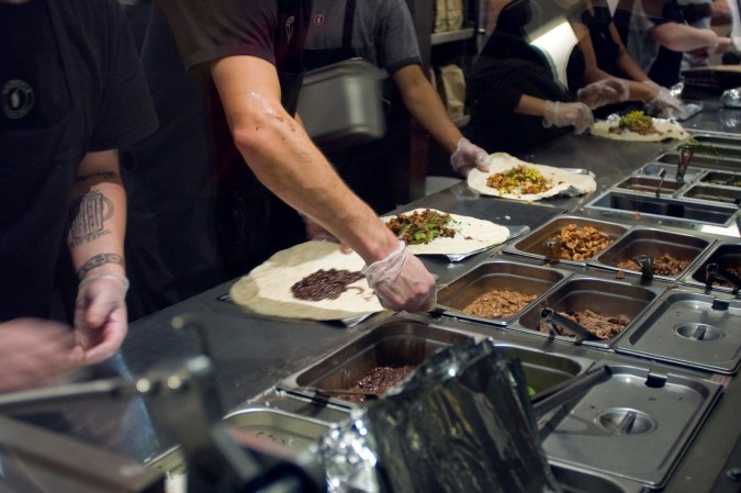Trabajadores preparan burritos en un Chipotle Mexican Grill en Midtown en Nueva York.