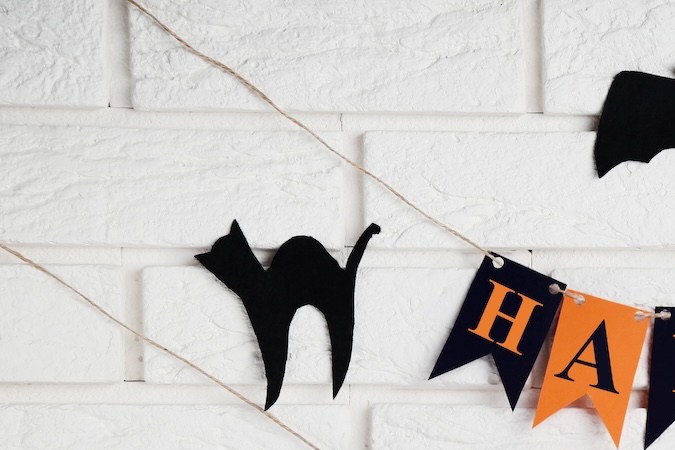 Decoraciones de Halloween de papel sobre fondo de pared de ladrillo.