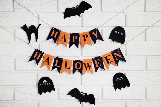 Decoraciones de Halloween de papel sobre fondo de pared de ladrillo.