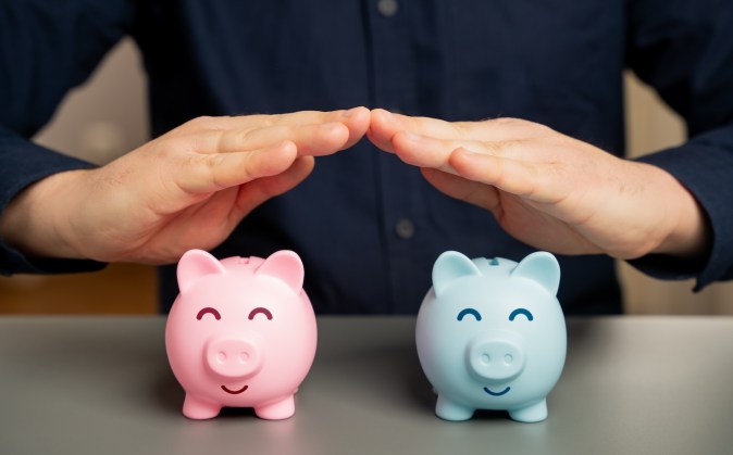 Dos alcancías en rosa y azul que representan las cuentas bancarias conjuntas.