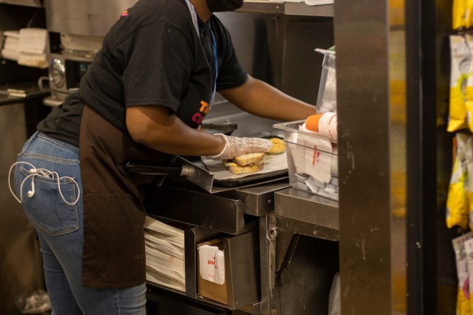 Se ve a un trabajador haciendo un sándwich en la cocina de una tienda de Dunkin' Donuts en el edificio de la terminal del Aeropuerto Internacional John F. Kennedy.