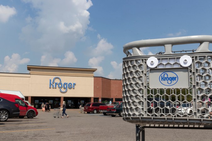 Fachada de una tienda Kroger con un carrito de compras en primer plano.