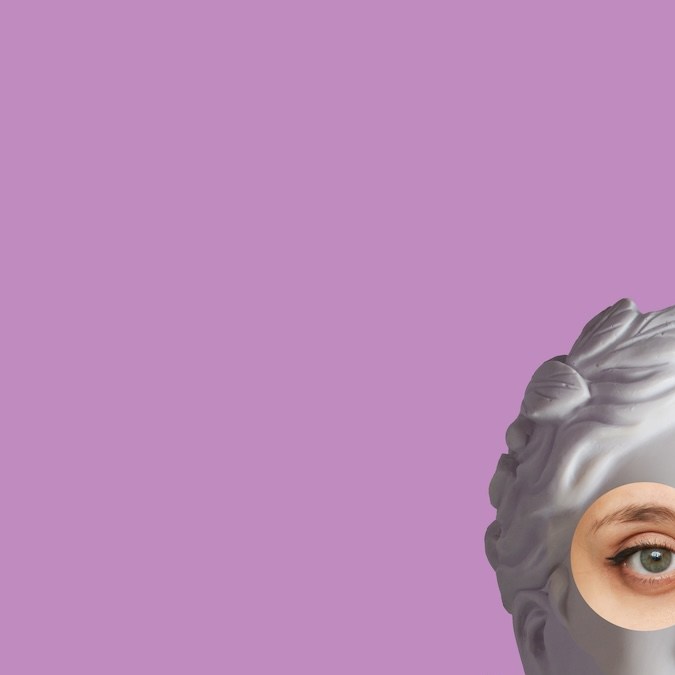 La cabeza de una estatua femenina antigua muestra el gesto de aprobación mientras sostiene un fajo de billetes de cien dólares aislados sobre un fondo de color violeta.