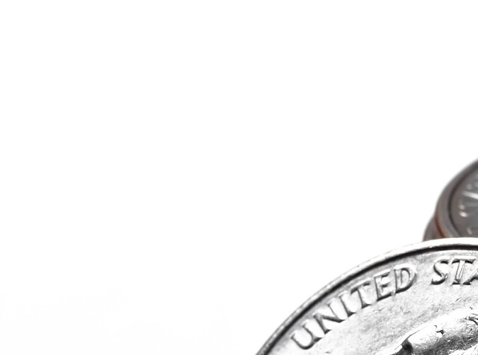 Primer plano de una pila de monedas de plata de veinticinco centavos.