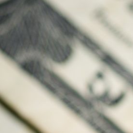 Columna de monedas de 25 centavos de dólar sobre billetes de EE.UU.