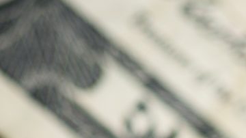 Columna de monedas de 25 centavos de dólar sobre billetes de EE.UU.