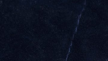 Vista de cerca de una bolsa de monedas antiguas de los Estados Unidos derramándose sobre madera rústica