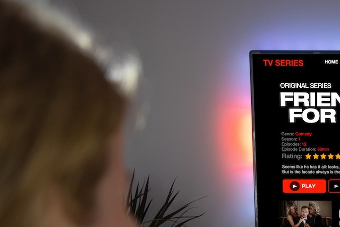 Mujer viendo series de televisión y películas en el servicio de streaming online en casa.