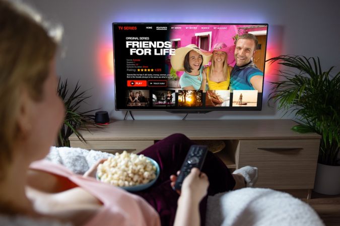 Mujer viendo series de televisión y películas en el servicio de streaming online en casa.