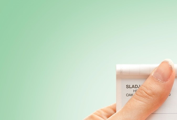 Manos femeninas llenando un cheque.