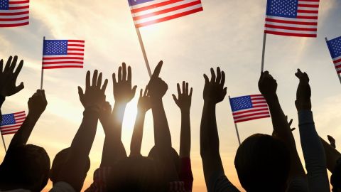 Siluetas de personas sosteniendo la bandera de Estados Unidos