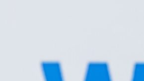 Carrito de compras con paquetes sobre el fondo del logotipo de Walmart.