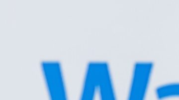 Carrito de compras con paquetes sobre el fondo del logotipo de Walmart.