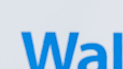Carrito de compras con paquetes sobre el fondo del logotipo de Walmart.