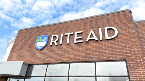 Primer plano de la farmacia y mercado de conveniencia Rite Aid, con el logotipo más nuevo en la pared de ladrillo.
