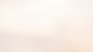 Mano usando un iPhone al aire libre al atardecer.