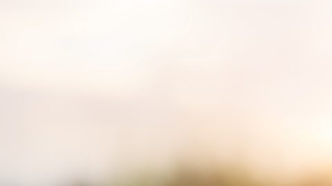 Mano usando un iPhone al aire libre al atardecer.