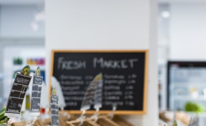 Mujer africana mayor comprando frutas frescas en el supermercado.