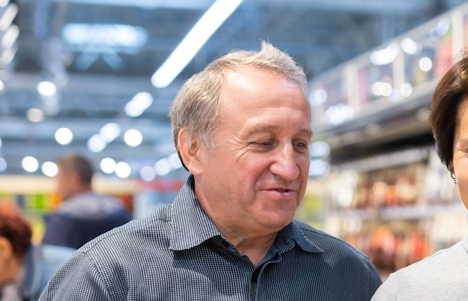 Pareja de clientes mayores en busca de salchichas en el supermercado.