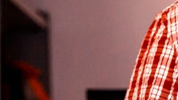 Un hombre sostiene una caja de cartón de Amazon.