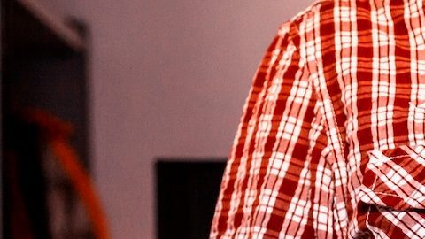 Un hombre sostiene una caja de cartón de Amazon.