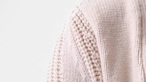 Mujer embarazada rodeada de dólares que caen del cielo, representando un cheque de estímulo.